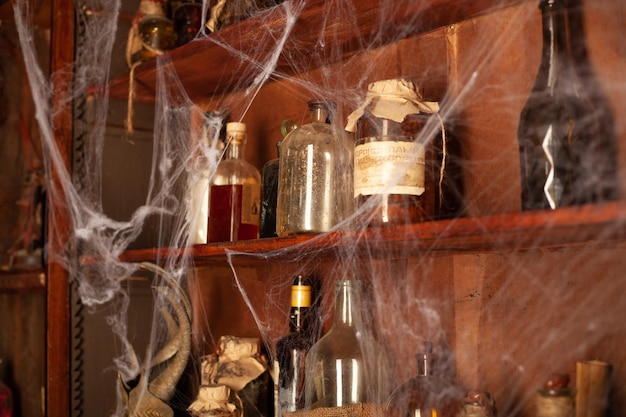 Sfondo di halloween mensole con strumenti di alchimia bottiglia di ragnatela di teschio con candele di veleno area di lavoro di witcher stanza di scarry