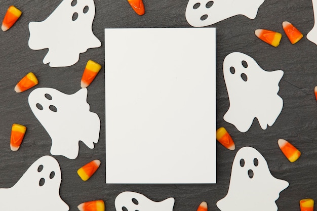 Photo halloween background with ghosts and candy corn on a slate background