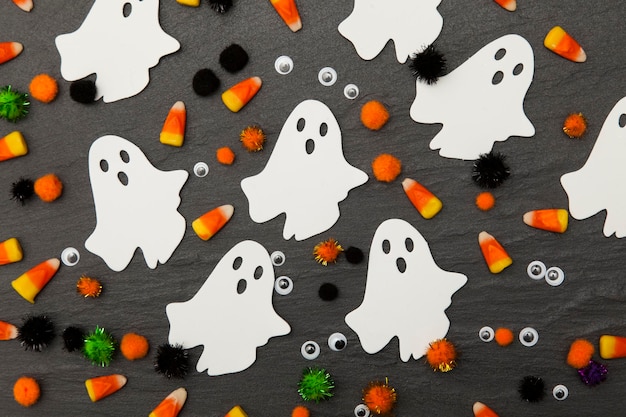 Photo halloween background with ghosts and candy corn on a slate background