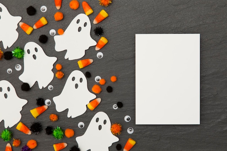 Photo halloween background with ghosts and candy corn on a slate background
