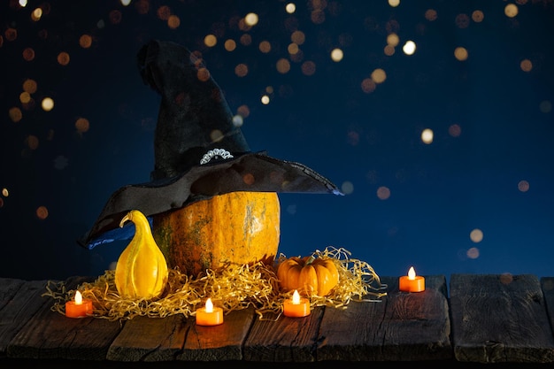 Halloween background with pumpkins candles on wooden table and bokeh