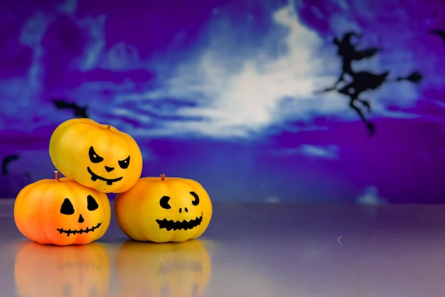 Halloween background with pumpkins on the face in the mystical forest at night