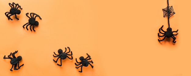 Halloween-banner met zwarte spinnen, Web op sinaasappel. Plat lag, bovenaanzicht. copyspace.