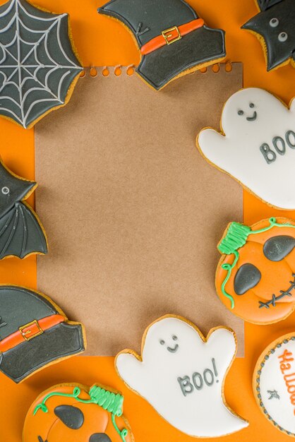 Halloween behandelt achtergrond met gesuikerde peperkoekkoekjes en snoepjes, Trick or treat concept bovenaanzicht kopieerruimte, trendy fel oranje kleur achtergrond