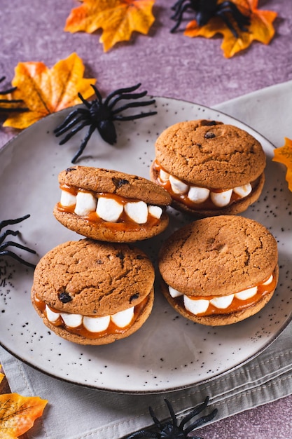 Halloween behandelt koekjes met marshmallow tanden op een bord en spinnen verticale weergave