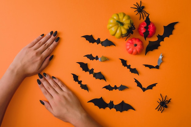 Halloween black manicure hand skin care spa salon October discounts Female hands on an orange