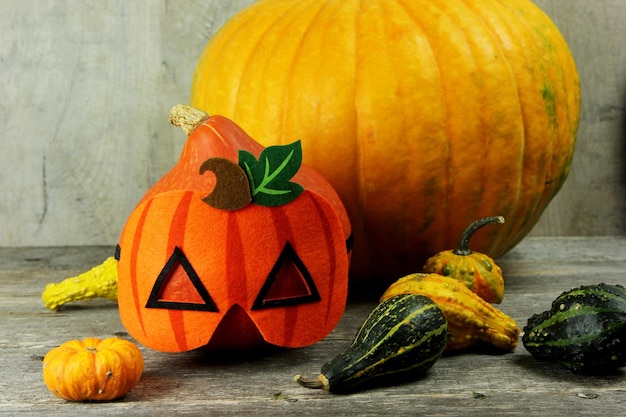 Halloween bucket with candy and pumpkin on a wooden background