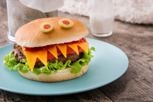 Halloween burger monster on wooden table