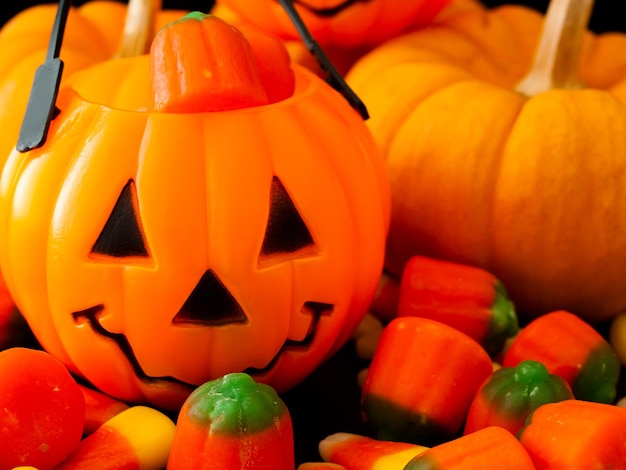 Halloween candies spilled on black background.