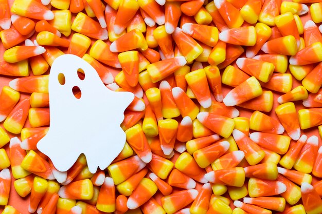 Photo halloween candy corn background with white ghost