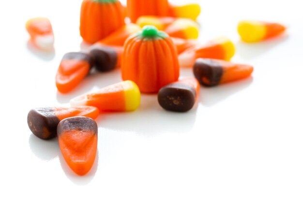 Halloween candy-corn and pumpkins in a pile.