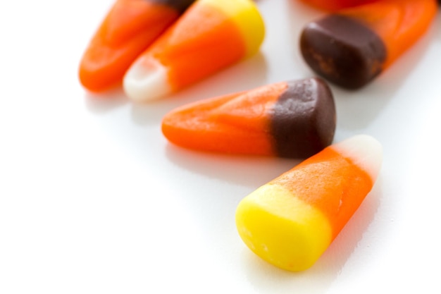 Halloween candy-corn and pumpkins in a pile.