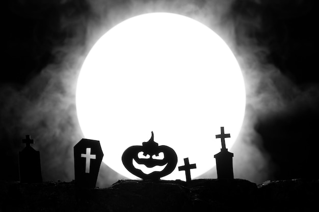 halloween cemetery with graves and pumpkin on the background of the moon with fog