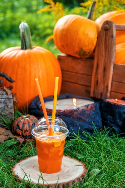 Cocktail di halloween con decorazione di zucche sullo sfondo. un pugno per una festa. jack-o-lantern.
