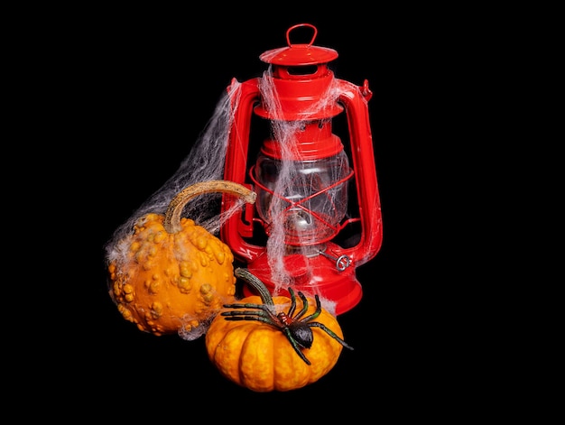 Foto composizione di halloween lampada a cherosene rossa e zucche su sfondo nero