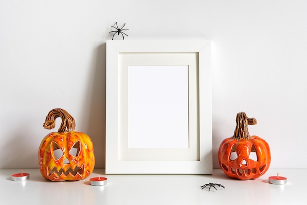 Halloween composition with ceramic pumpkins jack lantern and frame on table wall background Greeting card template