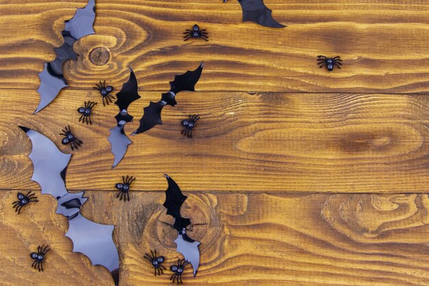 Halloween composition with spiders and bats on wooden background Top view copy space