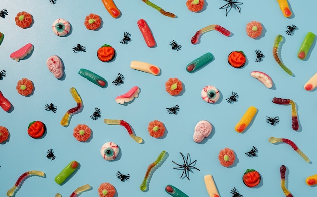 Halloween concept. Colorful sweets for Halloween party on blue background, top view flat lay