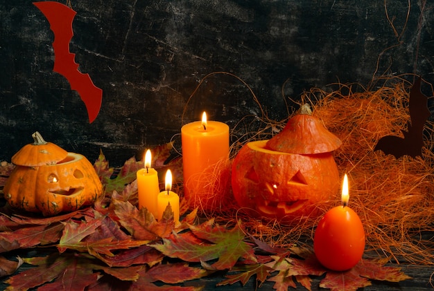 Halloween concept composition of pumpkins and candles on black background jacks lantern from pumpkin