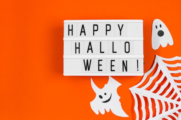 Halloween concept Feestelijke decoraties papieren geesten en spinnenweb op oranje achtergrond