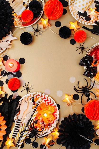 Foto concetto di halloween. cornice fatta di materiale decorativo per feste nero e arancione. disposizione piatta, vista dall'alto