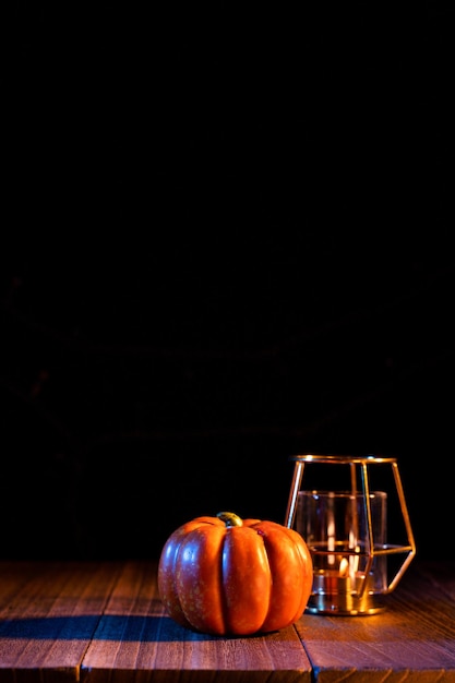 Halloween concept Orange pumpkin lantern on a dark wooden table with black background trick or treat close up