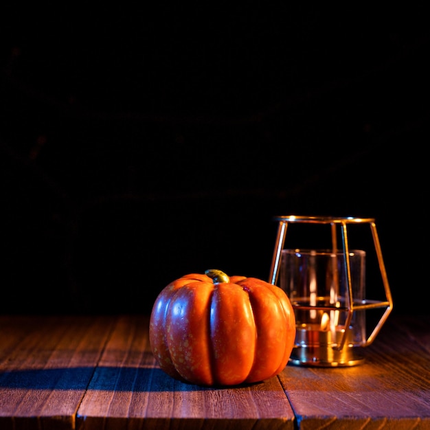 Halloween concept Orange pumpkin lantern on a dark wooden table with black background trick or treat close up