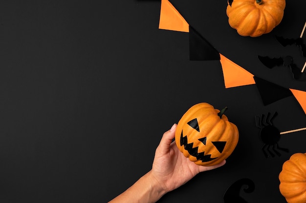 halloween concept pumpkin in hand on black background