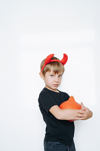 Halloween concept schattige kleine jongen met rode duivel hoorns geïsoleerd op een witte achtergrond