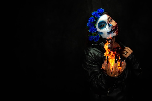 Halloween costume and makeup Portrait of Catrina with hands of fire