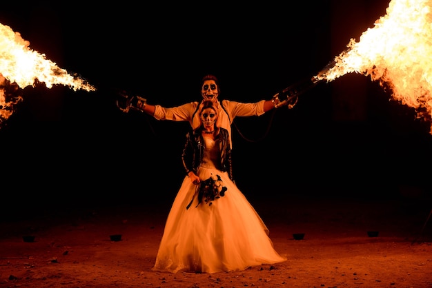 Halloween couple standing with flamethrower.