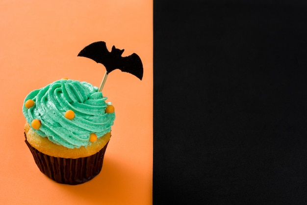 Halloween cupcake op oranje en zwarte achtergrond