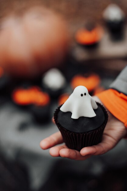 Halloween-cupcakes en vakantiedecor bij esdoornbladeren tussen bomen in het herfstseizoen buiten