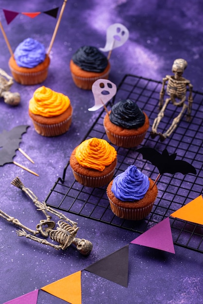 Halloween cupcakes met zwarte, paarse en oranje crème en decor
