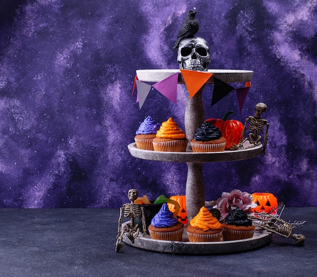 Halloween cupcakes with black, purple and orange cream and decor