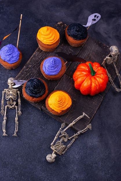 Halloween cupcakes with black, purple and orange cream and decor