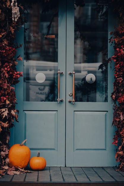 Halloween decorated front door with pumpkins and skeletons