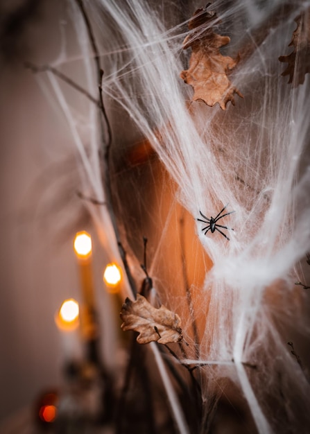 Halloween-decoraties wit spinnenweb op de achtergrond van brandende kaarsen in een donkere kamer in de avond verticaal horror