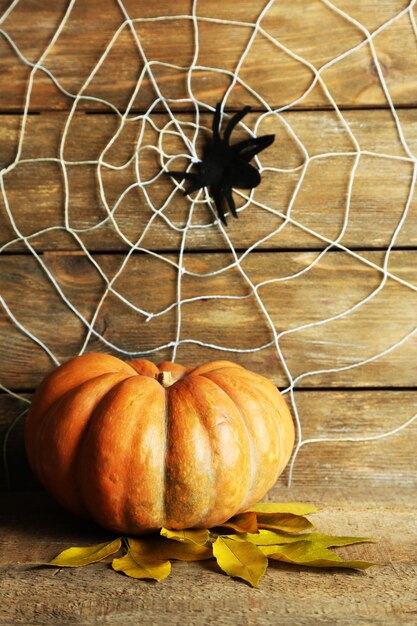 Photo halloween decoration with spider on web pumpkin and candles on wooden background