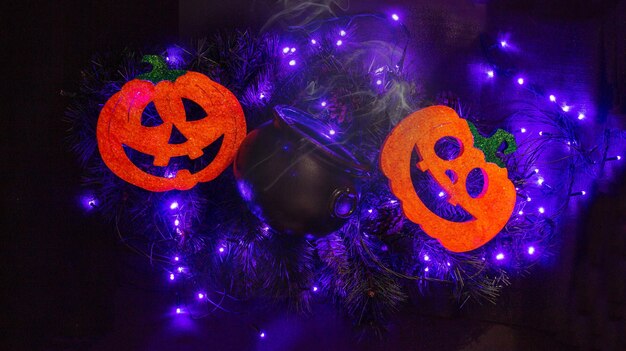 Halloween decoration with two pumpkins and a pot on some lights