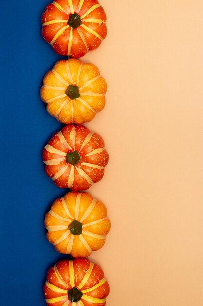 Halloween decorations concept Scary smile pumpkins are arranged on blue and cream background