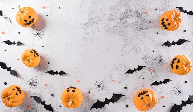 Halloween decorations made from pumpkin paper bats and black spider on stone