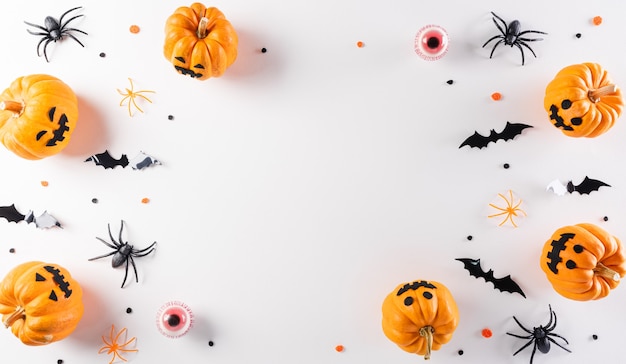 Halloween decorations made from pumpkin paper bats and black spider on white background