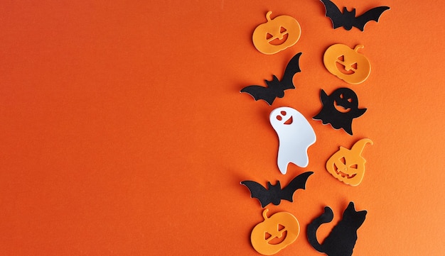 Halloween decorations, pumpkins, bats and ghosts on orange background