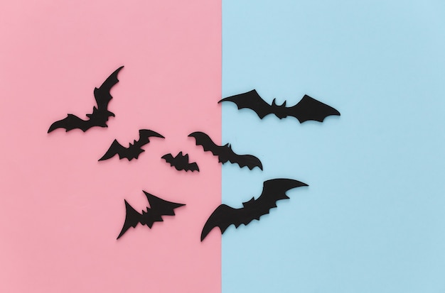 Halloween, decorations and scary concept. Black bats fly on pink blue