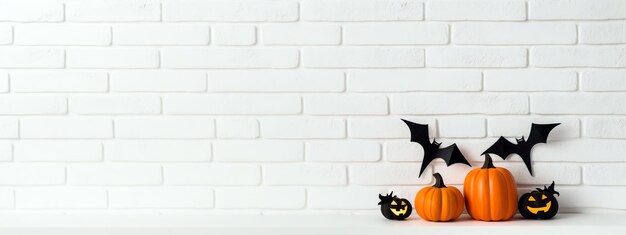 Photo halloween decorations white brick wall with bats and carved pumpkins