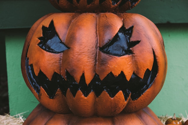 Foto una zucca jack-o-lantern decorativa di halloween di colore scuro sulla strada. concetto di celebrazione di halloween e carnevale.