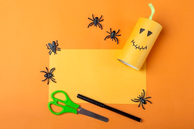 Halloween DIY and kids creativity. Step by step instruction: making orange monster pumpkin from toilet roll tube. Step2 finished work. Children Craft. Eco-friendly reuse recycle.