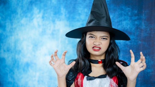 Девушка Дракулы Хэллоуина на синем фоне.