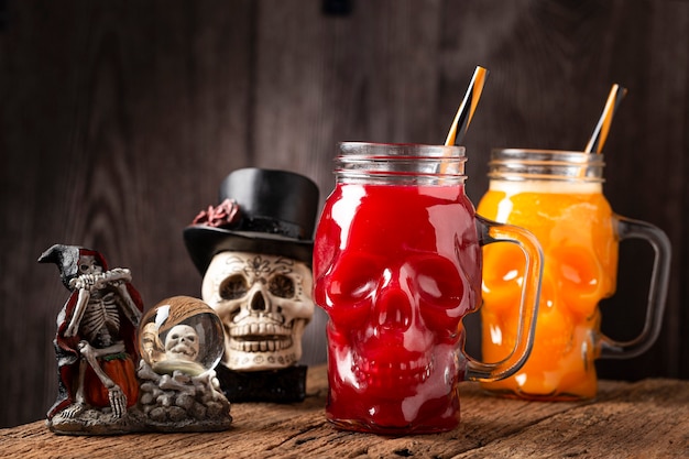 Halloween drink pumpkin drink and blood drink in skull\
glass